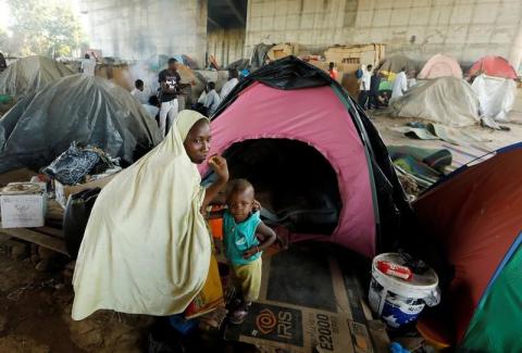 An African migrant sits with her son beside her tent at a makeshift camp set up under the bridge of a motorway on the outskirts of Algiers, Algeria, June 28, 2017. PHOTO BY REUTERS/Zohra Bensemra