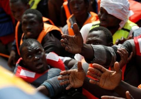 Migrants in a dinghy reach out towards Migrant Offshore Aid Station (MOAS) rescuers on board of the MOAS ship Topaz Responder around 20 nautical miles off the coast of Libya, June 23, 2016. PHOTO BY REUTERS/Darrin Zammit Lupi