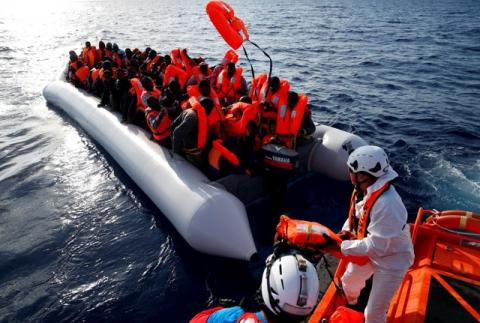 Migrants in a dinghy reach out for life jackets thrown to them by rescuers of the Migrant Offshore Aid Station (MOAS) some 20 nautical miles off the coast of Libya, June 23, 2016. PHOTO BY REUTERS/Darrin Zammit Lupi