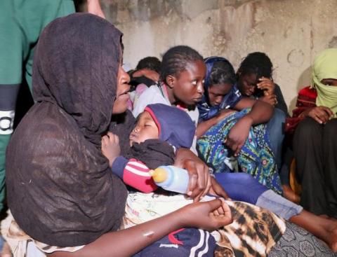 Illegal migrants, who attempted to flee the coast to Europe, sit after being detained and held at a Libyan Navy base in the the coastal city of Tripoli, September 20, 2015. PHOTO BY REUTERS/Hani Amara