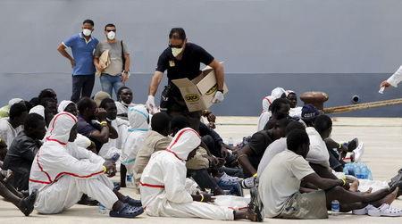 Migrants receive meals after disembarking from Italian Navy vessel Fenice in the Sicilian harbour of Augusta, Italy, May 31, 2015. PHOTO BY REUTERS/Antonio Parrinello