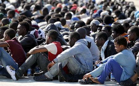 Migrants rest after disembarking from Coast Guard vessel Peluso in the Sicilian harbour of Augusta, Italy, June 3, 2015. PHOTO BY REUTERS/Antonio Parrinello