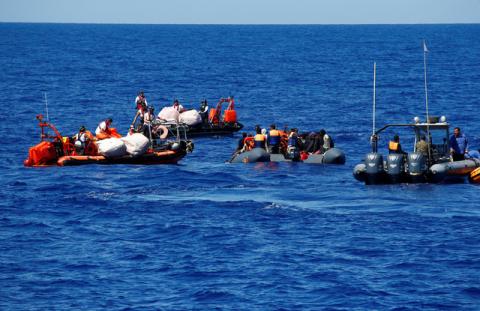 Migrants on a rubber boat are rescued by the SOS Mediterranee organisation during a search and rescue (SAR) operation, as the Libyan Coast Guard (R) patrols, in the Mediterranean Sea, off the Libyan Coast, September 14, 2017. PHOTO BY REUTERS/Tony Gentile