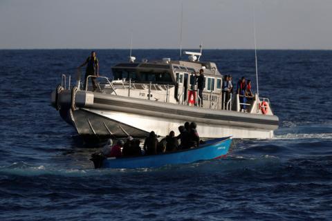 Migrants on a wooden boat are rescued by a patrol vessel of the Tunisia Navy, seen from the migrant search and rescue vessel MV Seefuchs of the German NGO Sea-Eye in the search and rescue zone south of the Al Jurf Oilfield in international waters off the coast of Libya, September 30, 2017. PHOTO BY REUTERS/Darrin Zammit Lupi