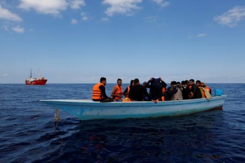 Libyan migrants on a wooden boat await rescue by the migrant search and rescue vessel MV Seefuchs (rear) of the German NGO Sea-Eye south of the Al Jurf Oilfield some 45 nautical miles off the coast of Libya, October 1, 2017. PHOTO BY REUTERS/Darrin Zammit Lupi