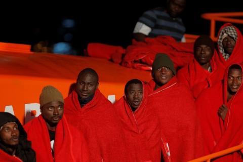 Migrants, part of a group intercepted aboard a dinghy off the coast in the Mediterranean Sea, look on as they stand on a rescue boat upon arrival on Christmas day at the port of Malaga, Spain, December 25, 2017. PHOTO BY REUTERS/Jon Nazca