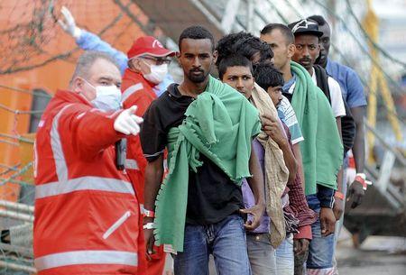 Migrants disembark from the Norwegian vessel Siem Pilot Stavanger in the Sicilian harbour of Palermo, Italy June 24, 2015. REUTERS/Guglielmo Mangiapane