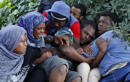 A group of migrants react as they are evacuated by Italian police from the Saint Ludovic border crossing on the Mediterranean Sea between Vintimille, Italy and Menton, France, June 16, 2015. PHOTO BY REUTERS/Eric Gaillard