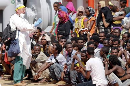 Migrants wait to disembark from a merchant ship in the Sicilian harbour of Pozzallo, Italy, August 2, 2015. PHOTO BY REUTERS/Antonio Parrinello