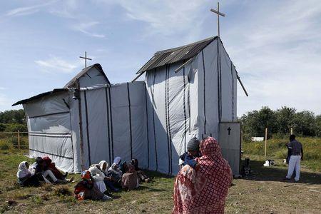 Christian migrants from Eritrea and Ethiopia attend the Sunday mass at the makeshift church in "The New Jungle" near Calais, France, August 2, 2015. PHOTO BY REUTERS/Pascal Rossignol