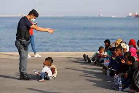 A policeman talks with children as migrants disembark from Migrant Offshore Aid Station (MOAS) ship Topaz Responder in the Sicilian harbour of Augusta, Italy, June 30, 2016. PHOTO BY REUTERS/Antonio Parrinello