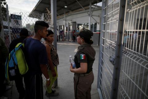 Migrants from Honduras, part of a new caravan from Central America trying to reach the United States, talk with a Mexican immigration officer on the border bridge between Mexico and Guatemala immigration in Ciudad Hidalgo, Mexico, January 17, 2019. PHOTO BY REUTERS/Jose Cabezas