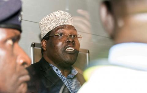 Miguna Miguna, a lawyer of dual Kenyan and Canadian citizenship, is seen through as glass door at the Jomo Kenyatta airport after he was detained by police in Nairobi, Kenya March 26, 2018, during an attempt to force him onto a plane to Canada. PHOTO BY REUTERS/Stephen Mdunga