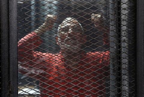 Muslim Brotherhood's leader Mohamed Badie shouts slogans against the Interior Ministery behind bars during the trial of 738 brotherhood members for their armed sit-in at Rabaa square, at a court on the outskirts of Cairo, Egypt May 31, 2016. PHOTO BY REUTERS