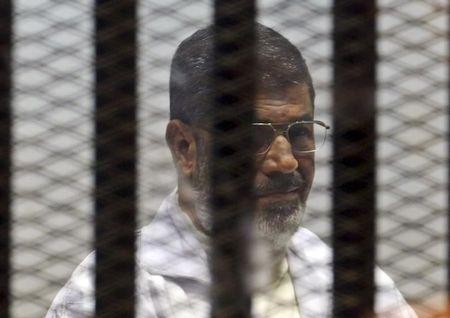 Former Egyptian President Mohamed Mursi sits behind bars with other Muslim Brotherhood members at a court in the outskirts of Cairo, December 29, 2014. PHOTO BY REUTERS/Asmaa Waguih