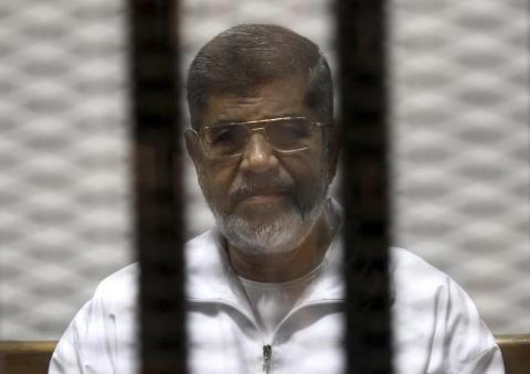 Ousted Egyptian President Mohamed Mursi is seen behind bars during his trial at a court in Cairo