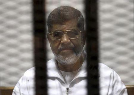 Ousted Egyptian President Mohamed Mursi is seen behind bars during his trial at a court in Cairo, May 8, 2014. PHOTO BY REUTERS/Stringer