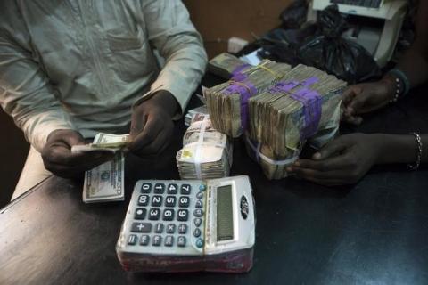 A trader changes dollars with naira at a currency exchange store in Lagos, February 12, 2015. PHOTO BY REUTERS/Joe Penney