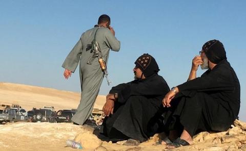 Monks look at an armed policeman following an attack by gunmen on a group of Coptic Christians. PHOTO BY REUTERS/Mohamed Abd El Ghany