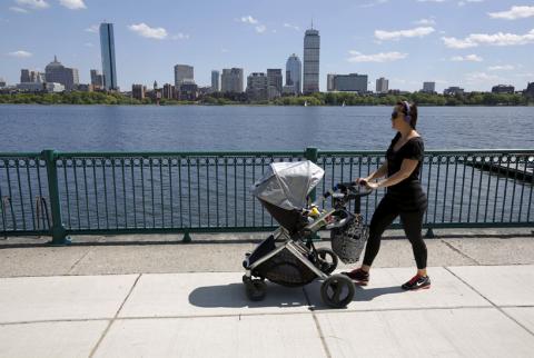 A woman pushes a baby stroller along the Charles River past the Boston skyline in Cambridge, Massachusetts, United States, June 10, 2015. PHOTO BY REUTERS/Brian Snyder