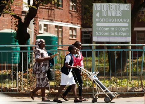 A nurse assisits a mother and her child outside Harare Central Hospital as the country's public sector doctors began a strike in Harare, Zimbabwe, September 3, 2019. PHOTO BY REUTERS/Philimon Bulawayo