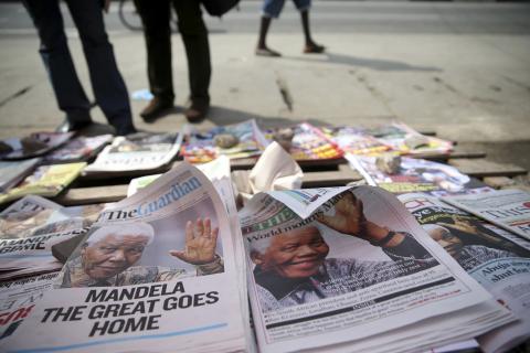 Newspapers with front pages depicting South Africa's former President Nelson Mandela are displayed at a vendor's stand in Ikoyi district in Lagos