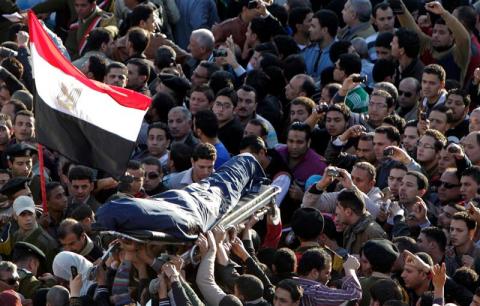 Mourners carry a wrapped body during a funeral service for policemen and people killed in a car bomb explosion, near Al Naser Mosque in Egypt's Nile Delta city of Mansoura in Dakahlyia province