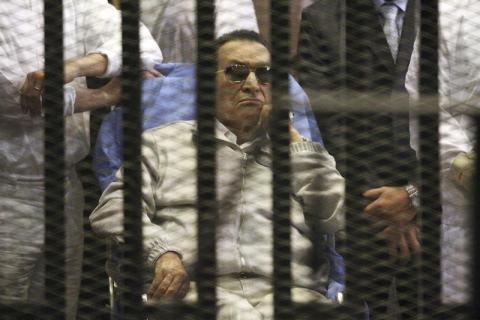 Egypt's ousted President Hosni Mubarak sits inside a dock at the police academy on the outskirts of Cairo