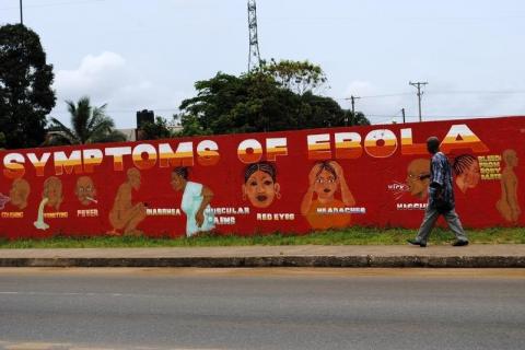 A man walks by a mural that reads "Symptoms of Ebola" in Monrovia, Liberia, October 12, 2014. PHOTO BY REUTERS/James Giahyue