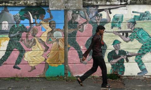 A man walks past a mural depicting fighting during the war in Colombo April 27, 2011. Sri Lanka on Tuesday rejected a report ordered by the U.N. chief blaming it for thousands of civilian deaths at end of its civil war, and said it can defend itself should the world body formally take up the accusations. PHOTO BY REUTERS/Andrew Caballero-Reynolds