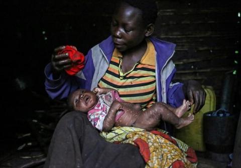 Mwenyezi, 36, washes her baby who is suffering from fever, at Kagorwa Pygmy camp on Idjwi island in the Democratic Republic of Congo, November 24, 2016. Mwenyezi cannot afford to take her baby for medical care. Her baby has scars from "bleeding," which some Pygmies use to try and treat certain diseases. REUTERS/Therese Di Campo