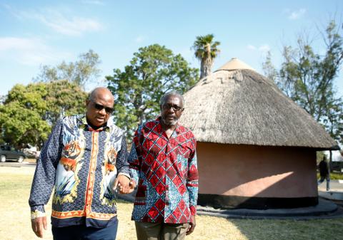 Former Zimbabwe President Robert Mugabe's nephews Leo Mugabe and Philip Chiyangwa hold hands as they walk at their uncle's rural homestead in Kutama, Zimbabwe, September 7,2019.REUTERS/Philimon Bulawayo