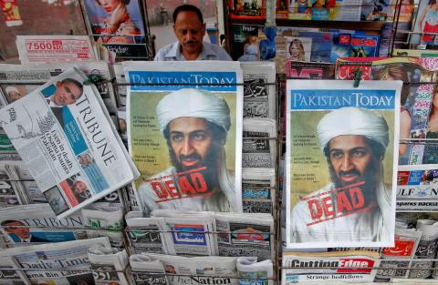 A roadside vendor sells newspapers with headlines about the death of al Qaeda leader Osama bin Laden, in Lahore, May 3, 2011. PHOTO BY REUTERS/Mohsin Raza