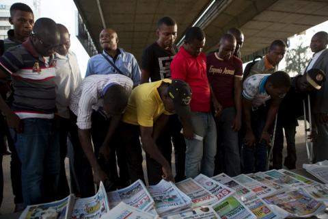 Men read newspaper headlines at a street side newsstand in Lagos, Nigeria, March 30, 2015. PHOTO BY REUTERS/Joe Penney