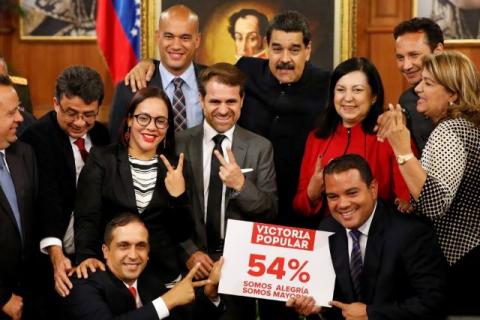 Venezuela's President Nicolas Maduro poses for a picture with new elected governors after a news conference at Miraflores Palace in Caracas, Venezuela, October 17, 2017. The placard reads, "Popular victory, 54%, we are joy, we are majority". PHOTO BY REUTERS/Carlos Garcia Rawlins