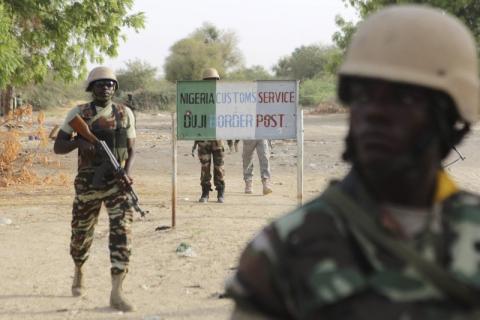 Nigerien soldiers walk past a customs signpost in Duji, Nigeria, March 25, 2015. PHOTO BY REUTERS/Joe Penney