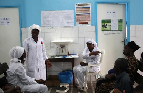 Nurses talk near a poster (C) displaying a government message against Ebola, at a maternity hospital in Abidjan