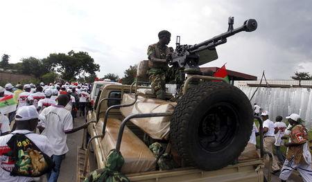 A Burundi military officer holds his machine gun as supporters of the Conseil National pour la Defense de la Democratie - Forces pour Defense de la Democratie (CNDD-FDD) party leave after their congress in the capital Bujumbura, April 25, 2015. PHOTO BY REUTERS/Thomas Mukoya