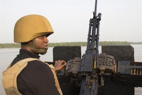 A naval officer mans a machine gun on a boat off the Atlantic coast in Nigeria's Bayelsa state