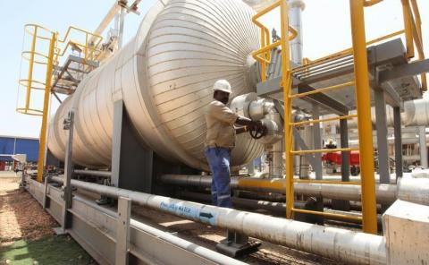 An oil worker turns a spigot at an oil processing facility in Palouge oil field in Upper Nile state