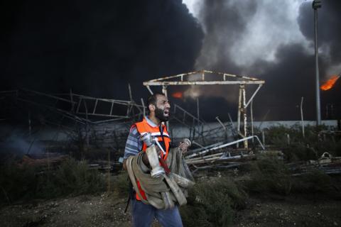 A Palestinian firefighter reacts as he tries to put out a fire at Gaza's main power plant, which witnesses said was hit in Israeli shelling, in the central Gaza Strip