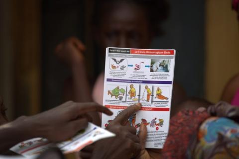 A UNICEF worker shares information on Ebola and best practices to help prevent its spread with residents of the Matam neighborhood of Conakry, Guinea