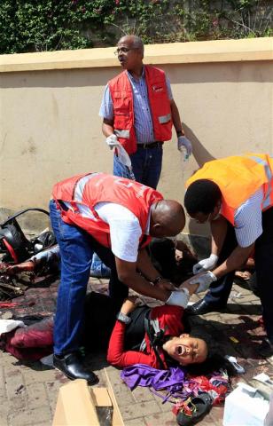 Paramedics help an injured victim after a shooting spree at Westgate shopping centre in Nairobi