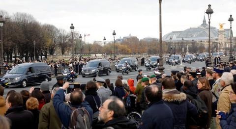 Soldiers and citizens pay tribute as hearses with the coffins of late thirteen French soldiers killed in Mali make their way past the Alexandre III bridge before a ceremony at the Hotel National des Invalides in Paris, France, December 2, 2019. PHOTO BY REUTERS/Charles Platiau