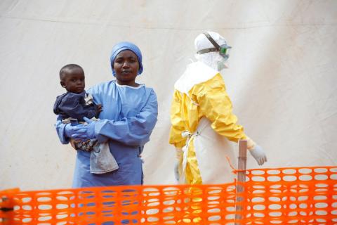 Mwamini Kahindo, an Ebola survivor working as a caregiver to babies who are confirmed Ebola cases, holds an infant outside the red zone at the Ebola treatment centre in Butembo, Democratic Republic of Congo, March 25, 2019. PHOTO BY REUTERS/Baz Ratner