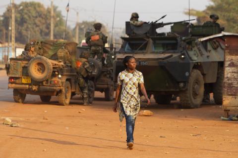 A woman walks past French peacekeeping troops in a street of the capital Bangui