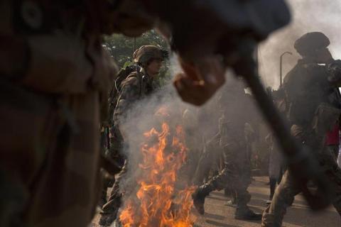 French peacekeeping soldiers try to control a crowd who have barricaded a street in the capital Bangui