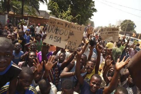 People gesture as they celebrate the resignation of Central African Republic's interim President Michel Djotodia in Lakouenga district