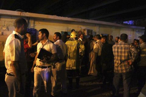 People gather at the site of a bomb blast in Cairo