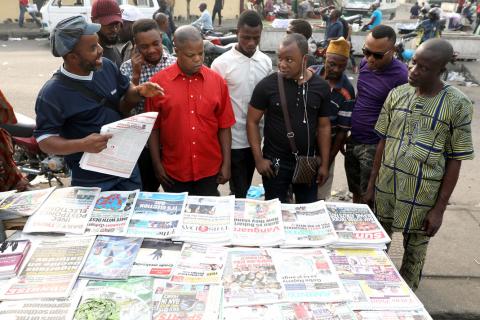 People read newspapers after the postponement of the presidential election in Lagos, Nigeria, February 16, 2019. PHOTO BY REUTERS/Temilade Adelaja